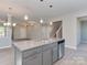 Open floor plan featuring a kitchen island overlooking a spacious living area with luxury vinyl plank flooring at 317 Contentment Dr, Locust, NC 28097