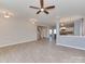 Open-concept living room featuring light gray wood floors, modern lighting, and seamless transition into the kitchen area at 317 Contentment Dr, Locust, NC 28097