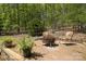 Outdoor patio with brick pavers, fire pit, and seating surrounded by lush greenery and trees at 3605 Ridgetop Rd, Sherrills Ford, NC 28673