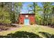 Exterior view of a shed with unique teal doors, nestled among mature trees and greenery at 3605 Ridgetop Rd, Sherrills Ford, NC 28673