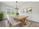 Bright dining room featuring a wooden table, white chairs, and large windows overlooking the yard at 408 Balboa St, Matthews, NC 28104