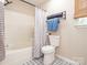 Bathroom features a tub, shower, and toilet, complemented by stylish black and white patterned floors at 4628 Arthur Way, Rock Hill, SC 29732