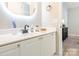 Bathroom vanity features a modern, rounded mirror, white cabinets and quartz countertops, blending style and functionality at 4628 Arthur Way, Rock Hill, SC 29732