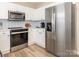 Bright kitchen featuring white cabinets, stainless steel appliances, and modern backsplash at 4628 Arthur Way, Rock Hill, SC 29732