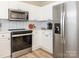Modern kitchen features stainless steel refrigerator and microwave with light countertops and backsplash at 4628 Arthur Way, Rock Hill, SC 29732