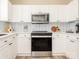 Contemporary kitchen featuring white cabinets, modern appliances, and a stylish backsplash at 4628 Arthur Way, Rock Hill, SC 29732