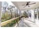 Relaxing back porch with a ceiling fan and views of the wooded backyard at 472 Bellingshire Dr, Mt Ulla, NC 28125