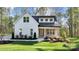 Charming two-story farmhouse with white siding, black roof, manicured lawn, and inviting front porch at 472 Bellingshire Dr, Mt Ulla, NC 28125