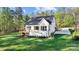Charming white two-story home with a wooden deck and long driveway surrounded by a lush lawn at 472 Bellingshire Dr, Mt Ulla, NC 28125