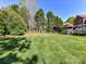 Large backyard featuring lush green grass, mature trees, and a charming fence, perfect for outdoor activities and relaxation at 7012 Chadwyck Farms Dr, Charlotte, NC 28226