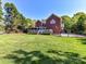 A well-maintained backyard features a spacious lawn, a deck with a gazebo, and beautiful landscaping, ideal for relaxation at 7012 Chadwyck Farms Dr, Charlotte, NC 28226