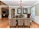 Formal dining room boasts hardwood floors, elegant chandelier, and large glass table at 7012 Chadwyck Farms Dr, Charlotte, NC 28226