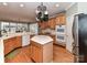 Open kitchen features a center island, stainless appliances, and wooden cabinetry at 7012 Chadwyck Farms Dr, Charlotte, NC 28226