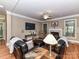 Relaxing living room with fireplace, hardwood floors, and comfortable leather seating at 7012 Chadwyck Farms Dr, Charlotte, NC 28226