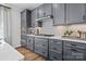 Modern kitchen featuring stylish gray cabinets, a tile backsplash, and stainless steel appliances at 7105 Short Stirrup Ln, Mint Hill, NC 28227