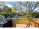 Wooden deck with grill overlooks the fenced backyard featuring a storage shed and trees at 713 8Th Street Nw Dr, Hickory, NC 28601