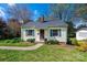 Charming yellow home with green shutters, black roof, and manicured landscaping at 713 8Th Street Nw Dr, Hickory, NC 28601