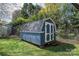 Outdoor shed with gray roof, blue siding and white trim is fenced in at 713 8Th Street Nw Dr, Hickory, NC 28601