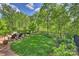 Spacious backyard with lush lawn, mature trees, patio with comfortable chairs, and manicured landscaping at 727 Bluff Loop Rd, Rock Hill, SC 29730
