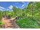 Scenic view of backyard featuring a stone fireplace, patio seating, and professionally landscaped garden at 727 Bluff Loop Rd, Rock Hill, SC 29730