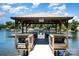 View of the wooden boat dock featuring a metal roof, built-in benches, and a gated entry at 7829 Village Harbor Dr, Cornelius, NC 28031