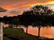 Picturesque lake view at sunset with silhouetted trees and golden reflections at 7829 Village Harbor Dr, Cornelius, NC 28031