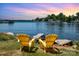 Stunning waterfront view with two yellow chairs and colorful sky at 7829 Village Harbor Dr, Cornelius, NC 28031