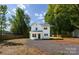Charming two-story home with a gravel driveway and a well-manicured lawn and mature trees at 8722 Moody Rd, Charlotte, NC 28215