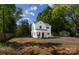 This house is a two-story home with a gravel driveway and a well-manicured lawn and mature trees at 8722 Moody Rd, Charlotte, NC 28215