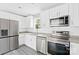 This kitchen is has stainless appliances, granite countertops, white subway tile, and gray wood-look floors at 8722 Moody Rd, Charlotte, NC 28215