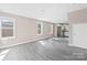 Bright living room featuring gray wood-look floors and several windows for natural light and an open floor plan at 8722 Moody Rd, Charlotte, NC 28215
