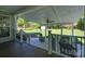 A covered back porch features a ceiling fan, gray Adirondack chair, black railings and outdoor grill overlooking a landscaped yard at 921 Snow Prince Ln, York, SC 29745