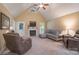 Cozy living room featuring a fireplace, neutral carpet, high ceiling, ceiling fan, and comfortable seating at 921 Snow Prince Ln, York, SC 29745