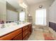 Well-lit bathroom with dual sinks, a large mirror, tile floors, and plenty of storage space at 10024 Fox Trotter Ln, Midland, NC 28107