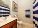 Bright bathroom with a cherry vanity, blue and white striped shower curtain, and coordinated towel set at 10024 Fox Trotter Ln, Midland, NC 28107