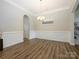 Formal dining room with chair rail, a modern chandelier, and wood-look floors for elegant entertaining at 10024 Fox Trotter Ln, Midland, NC 28107