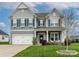 Beautiful two-story home with blue shutters, gray siding, and a well-manicured lawn at 10024 Fox Trotter Ln, Midland, NC 28107