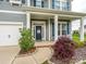Charming front porch with a 'Welcome' wreath, cozy seating, and manicured landscaping at 10024 Fox Trotter Ln, Midland, NC 28107