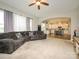 Open living room featuring a gray sofa, ceiling fan, and an archway leading to the kitchen with stainless steel appliances at 10024 Fox Trotter Ln, Midland, NC 28107
