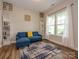 Bright living room with wood floors, natural light, and a stylish blue couch for relaxation at 10024 Fox Trotter Ln, Midland, NC 28107