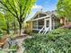 Landscaped backyard with screened-in porch, lush greenery, stone patio, and comfortable seating at 10626 Newberry Park Ln, Charlotte, NC 28277