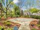 Spacious backyard with mature trees, brick house view, patio, and manicured landscaping at 10626 Newberry Park Ln, Charlotte, NC 28277