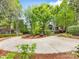 Circular driveway with lush landscaping and trees and partial house view at 10626 Newberry Park Ln, Charlotte, NC 28277