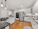 Modern kitchen with stainless steel appliances, granite countertops, white cabinets, and hardwood floors at 10626 Newberry Park Ln, Charlotte, NC 28277