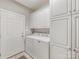 Well-lit laundry room with white cabinetry, washer, and dryer at 10626 Newberry Park Ln, Charlotte, NC 28277