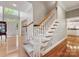 Elegant staircase with wooden banister, carpeted steps, and hardwood floors leading to the upper level at 10626 Newberry Park Ln, Charlotte, NC 28277