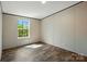 This bedroom offers wood-look flooring, a window overlooking a wooded lot, base molding, and crown molding at 110 Matthew Dr, Kings Mountain, NC 28086