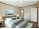 This staged bedroom includes a king bed with a grey headboard, an art piece, and coordinating lamps at 110 Matthew Dr, Kings Mountain, NC 28086