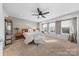 Bright main bedroom with a ceiling fan, three large windows, carpet and a bench seat at the foot of the bed at 11039 Stetler St, Charlotte, NC 28204