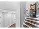 Well-lit staircase features wood steps with white risers, complemented by a dark wood railing and open shelving at 11039 Stetler St, Charlotte, NC 28204